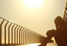 mulher sentada pensando na tristeza