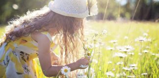 Ser otimista é dar um passo para a felicidade menina colhendo flor