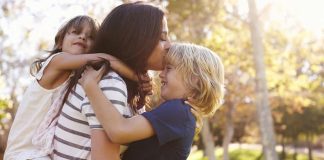 Significado do Beijo. Mãe beijando os filhos com carinho