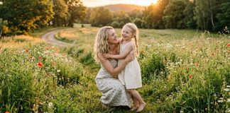 mãe e filha juntas num campo florido tendo um dia feliz
